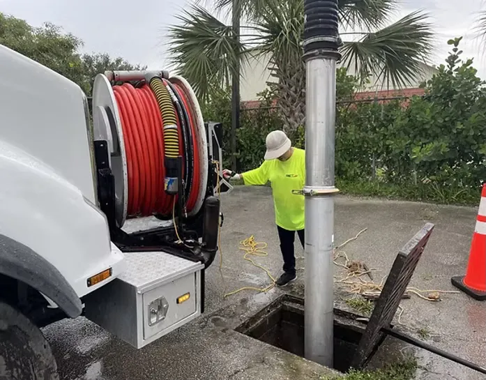 vac truck with jetter reel and vacuum tube cleaning out a drainage catch basin